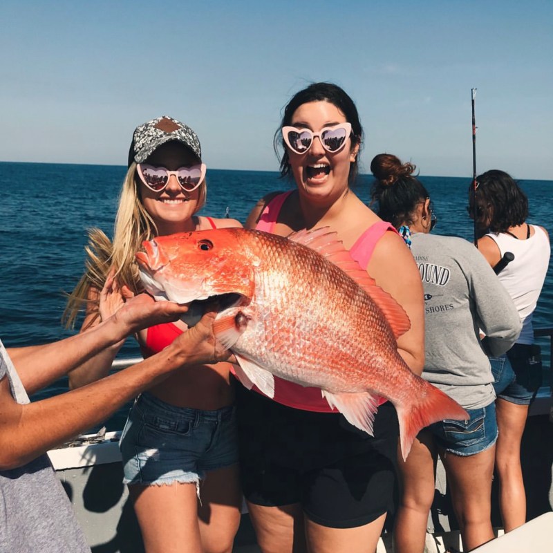 a woman holding a fish in the water