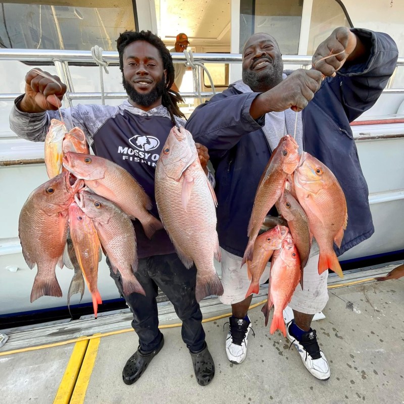 a group of people standing next to a stuffed animal