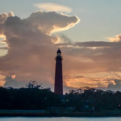 a sunset over a body of water with a city in the background